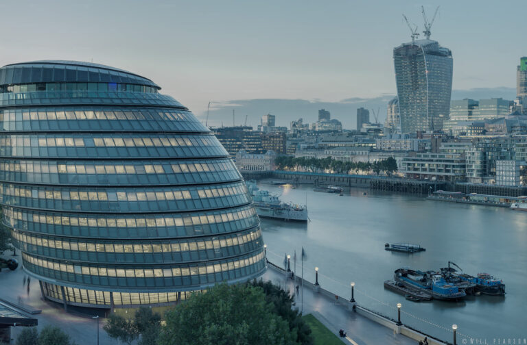 Tower Bridge Panorama 'Constant Thames' showing City Hall to the left across to Tower Bridge at the right, shown at twilight as the City of London lights up.